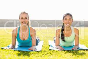Smiling sporty women on exercise mats
