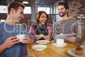 Group of friends enjoying a dessert with tablet