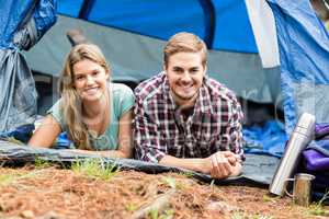 Portrait of a young happy couple lying in a tent