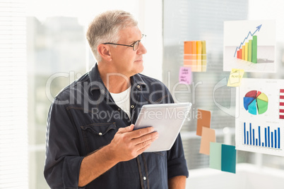 Attentive businessman looking flow charts on the wall