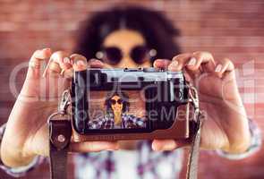 Attractive hipster taking selfies with camera