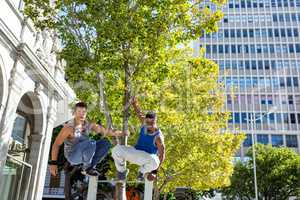 Happy friends doing parkour in the city