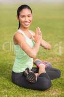 Smiling sporty woman doing the lotus pose