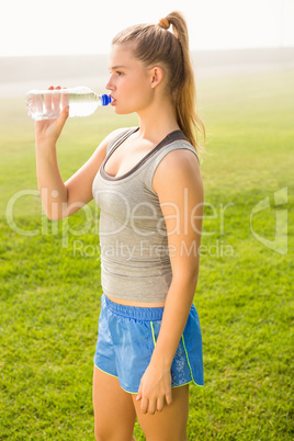 Sporty blonde drinking water out of bottle