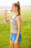 Sporty blonde drinking water out of bottle