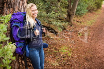 Smiling female hiker waiting by the side of the road
