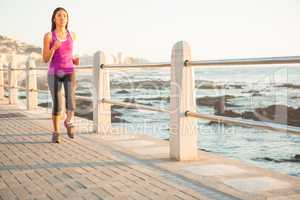 Fit woman jogging at promenade