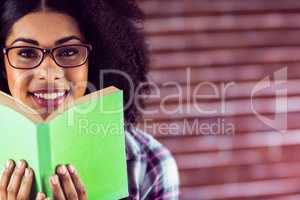 Attractive smiling hipster holding book