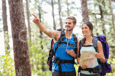 Happy hikers looking away holding map and compass