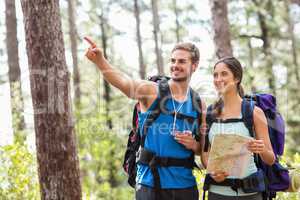 Happy hikers looking away holding map and compass
