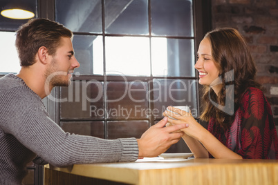 Smiling couple talking and drinking coffee