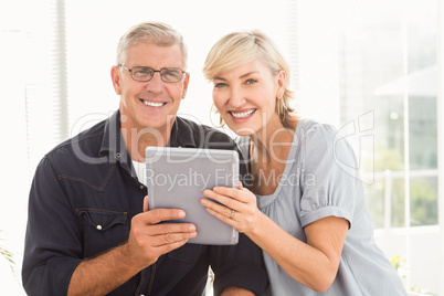 Smiling business team working over a tablet