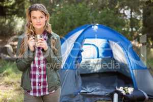 Pretty blonde camper standing in front of tent