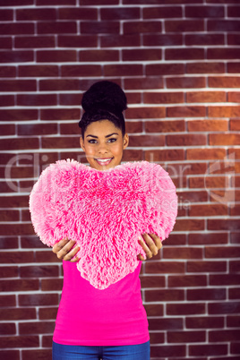 Portrait black hair model holding a pink heart shaped pillow