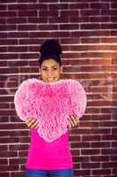 Portrait black hair model holding a pink heart shaped pillow