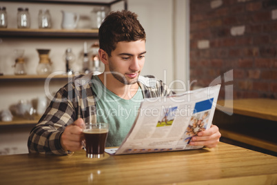 Hipster drinking coffee and reading newspaper