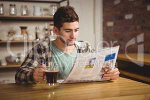 Hipster drinking coffee and reading newspaper