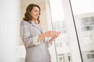 Smiling casual businesswoman using smartphone