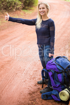 Pretty hitchhiker sticking thumb out