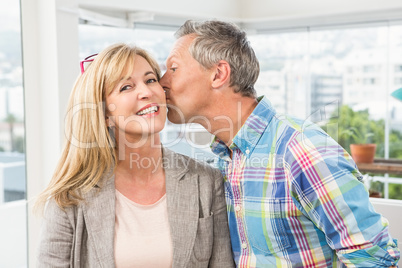 Casual designer giving his colleague kiss on cheek