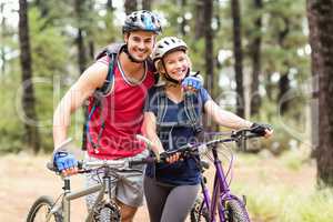 Happy young biker couple looking at camera