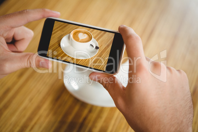 A man taking a photo of a coffee