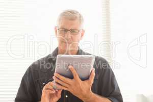 Attentive businessman scrolling on his tablet