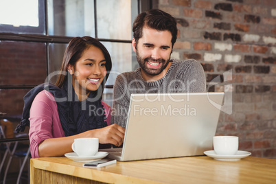 Young happy couple looking at a laptop