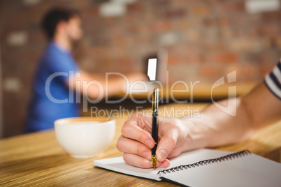 Young man taking notes in his notebook