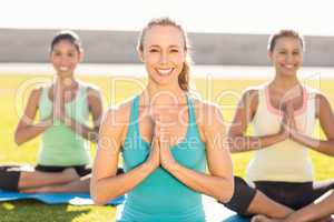Smiling sporty women doing lotus pose