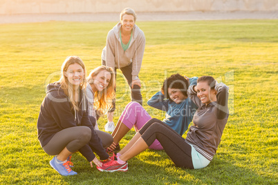 Smiling sporty women doing sit ups during fitness class