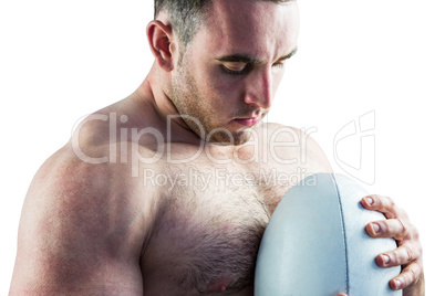 Shirtless rugby player holding ball