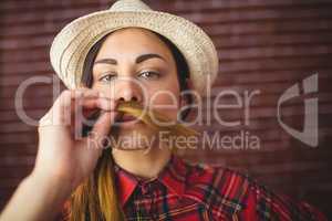 Beautiful hipster holding hair as mustache