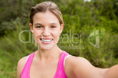 Pretty blonde athlete smiling and taking selfie