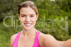 Pretty blonde athlete smiling and taking selfie