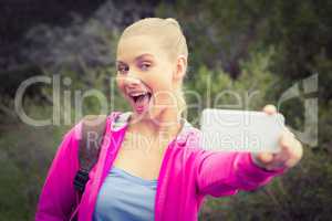Smiling female hiker taking a funny selfie
