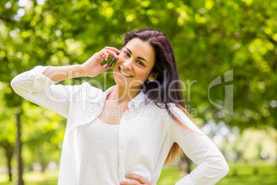 Beautiful brunette in the park making a call