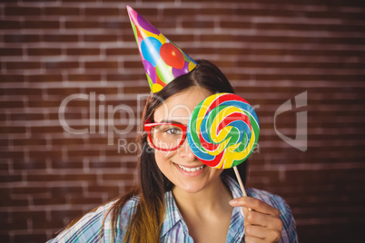 Pretty hipster with party hat and lollipop