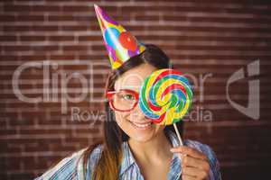 Pretty hipster with party hat and lollipop