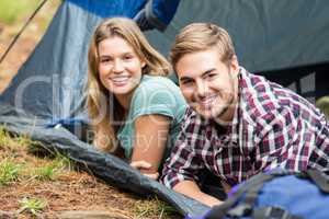 Portrait of a young happy couple lying in a tent