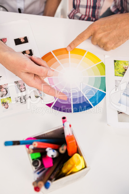 Casual designers working with colour chart and photographs
