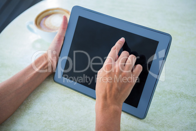 Woman using tablet on cafe terrace