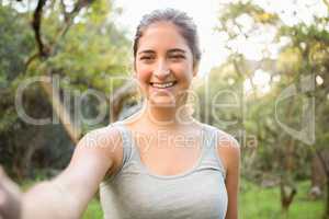 Smiling athletic brunette taking selfie