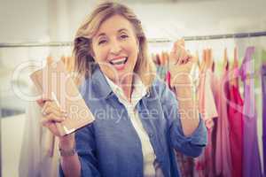Cheering woman going shopping and showing wallet