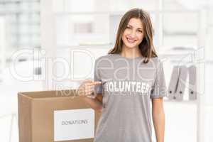 Smiling brunette volunteer showing her shirt