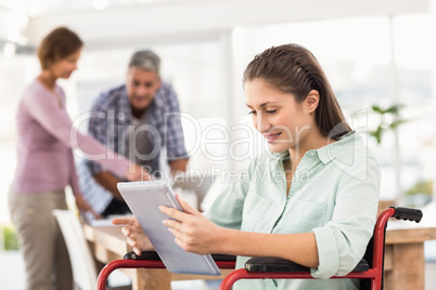 Casual businesswoman in wheelchair using tablet