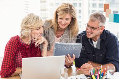 Smiling business team working over a tablet