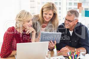 Smiling business team working over a tablet