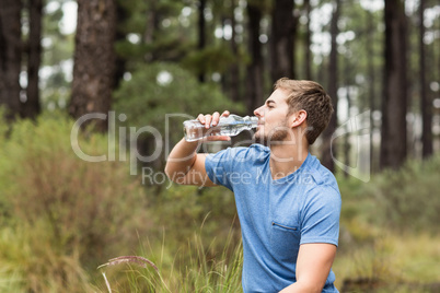 Young handsome man drinking water