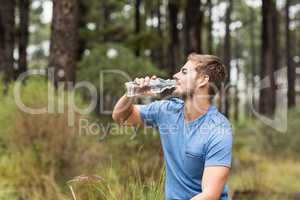 Young handsome man drinking water